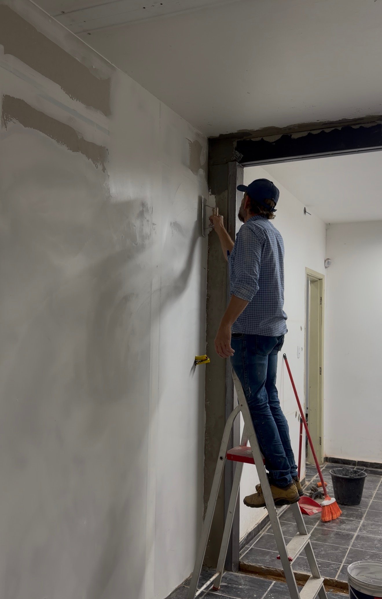 Valdir fazendo massa corrida em parede — reforma residencial em Goiânia