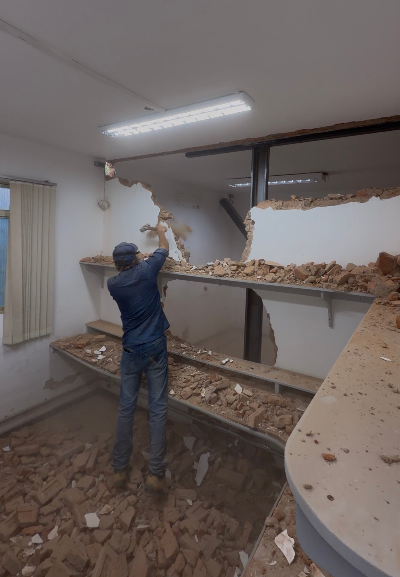 Valdir realizando demolição controlada de parede
